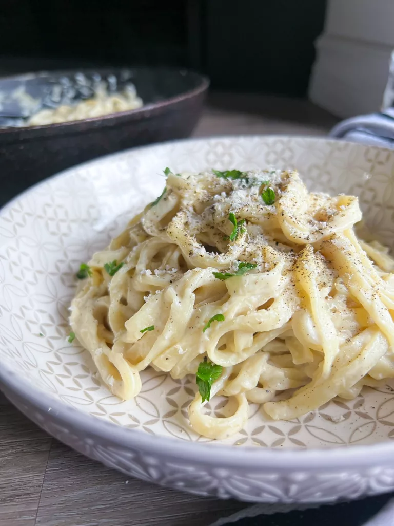 vegan pasta noodles with Alfredo sauce white bowl