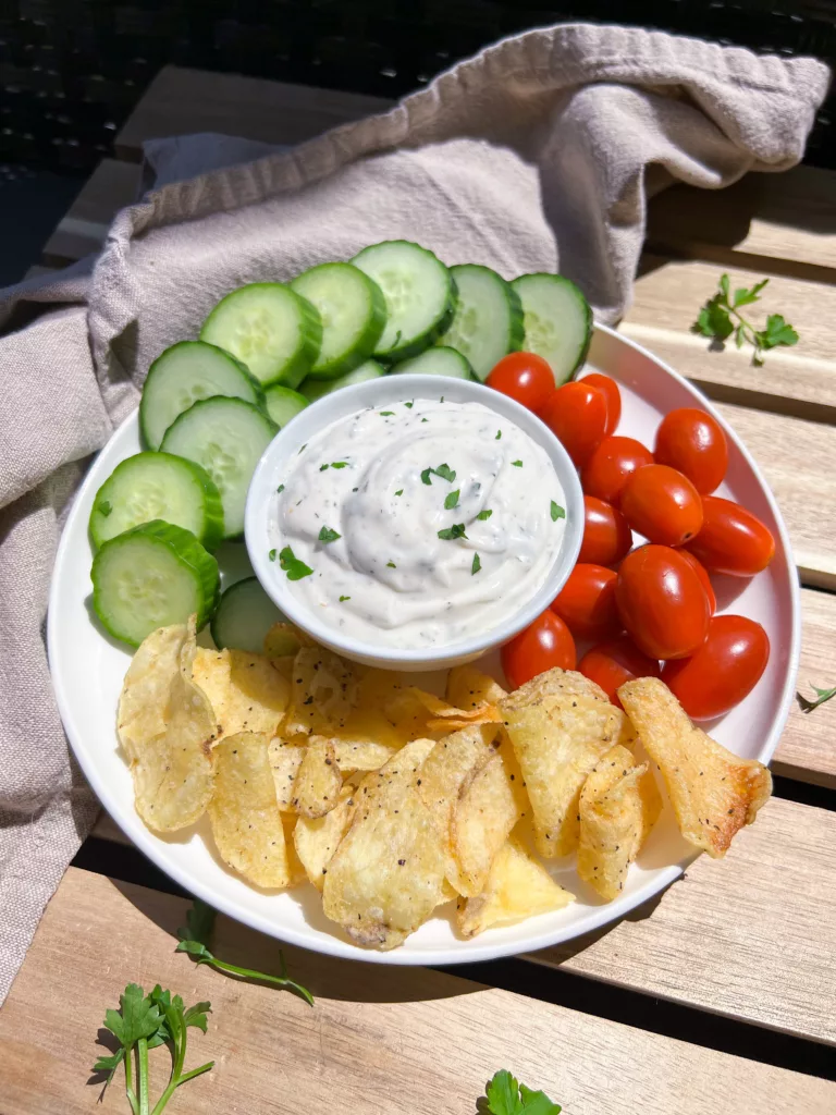 vegan ranch dip on plate with chips and veggies