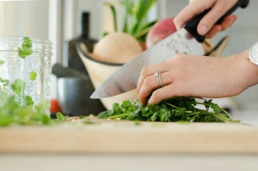 woman chopping fresh herbs parsley