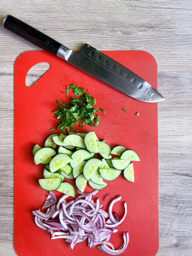 Cucumber onion Salad cut up on cutting board