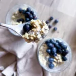lemon poppy seed overnight oats with blue berries on spoon