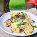 grilled cauliflower steaks on plate in park