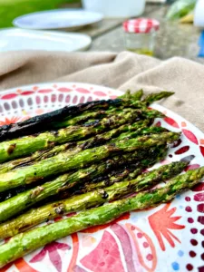 grilled asparagus on red and white plate