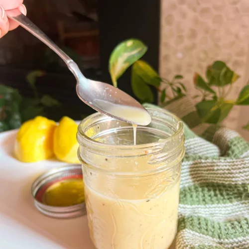 Lemon vinaigrette dressing with spoon