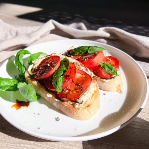 Sourdough bread sliced with cream cheese tomato basil and balsamic reduction