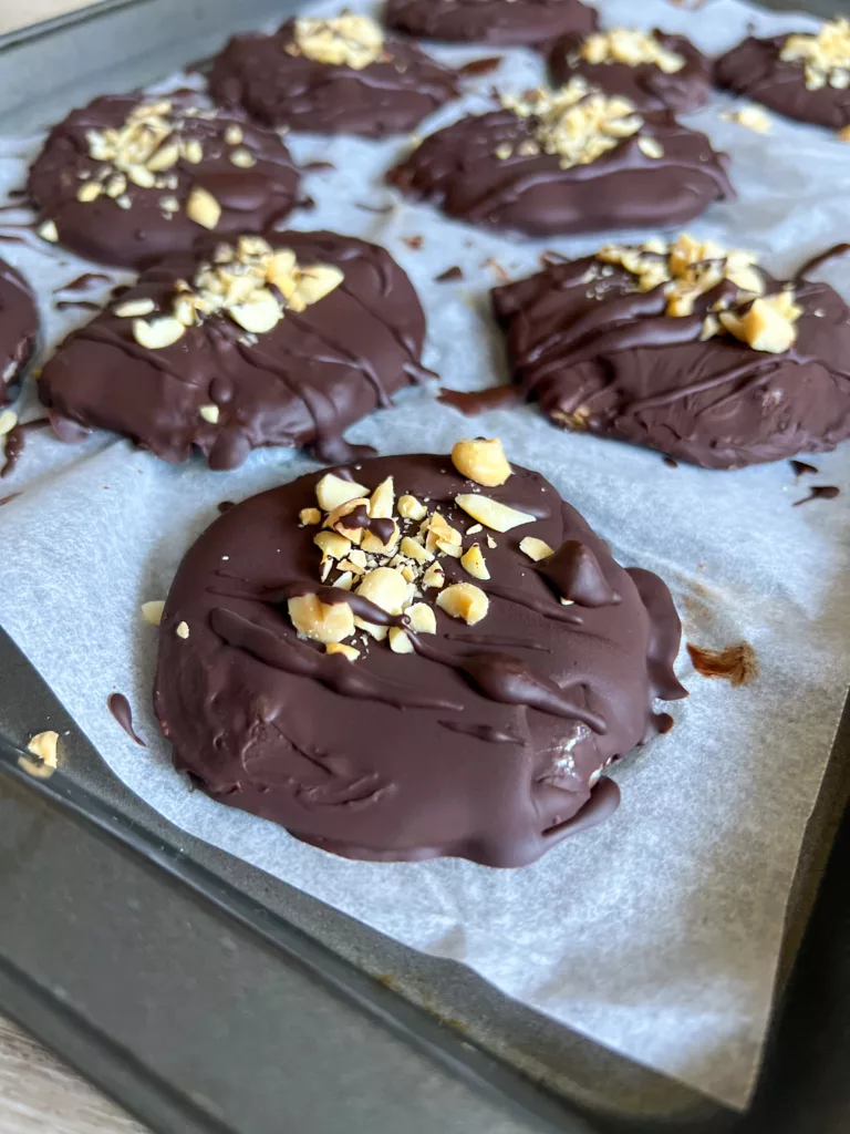 Peanut butter yogurt bites covered in chocolate and sprinkled with peanuts
