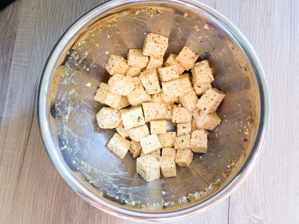 Tofu bites with spices in stainless steel bowl