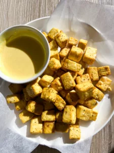 baked tofu bites on plate with dipping sauce