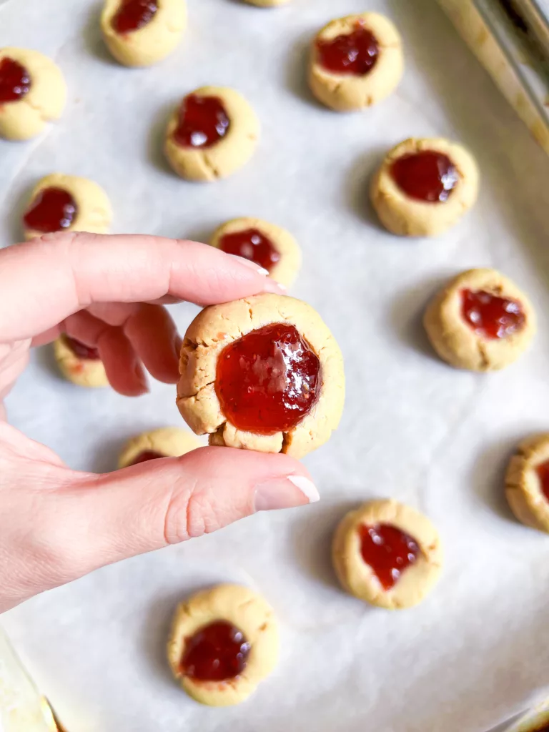 4 ingredient cookies thumb print cookies with jam hand holding cookie