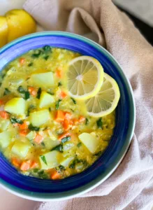 red lentil potato soup with lemons in bowl