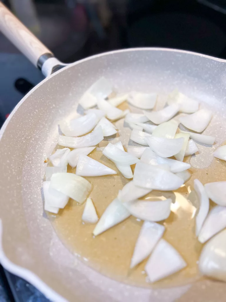 cooking onion in frying pan with oil