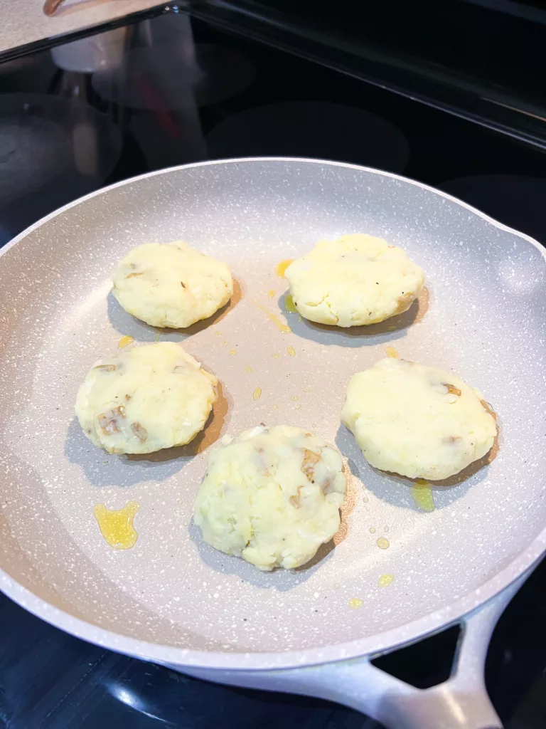 mashed potato pancakes cooking on pan