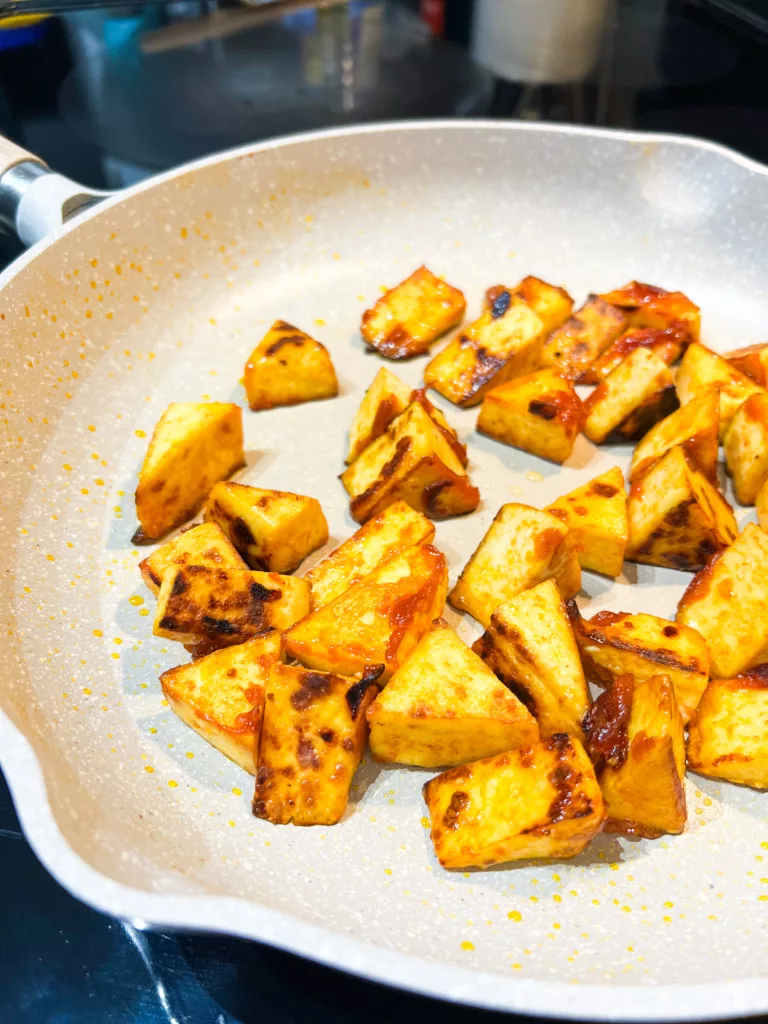 soy sauce, gochujang sauce, sesame oil, and cornstarch tofu in pan cooking