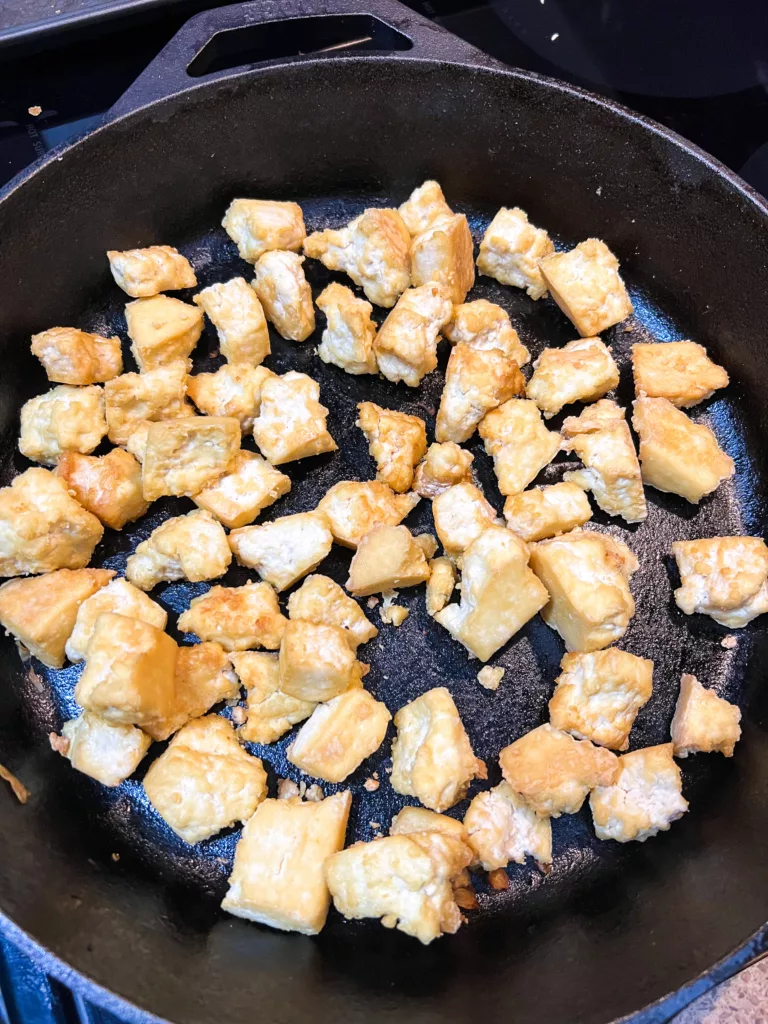 adding tofu to cast iron pan