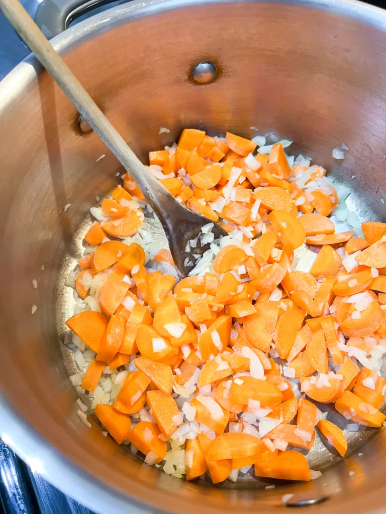 carrots and onions in stainless steel pot cooking