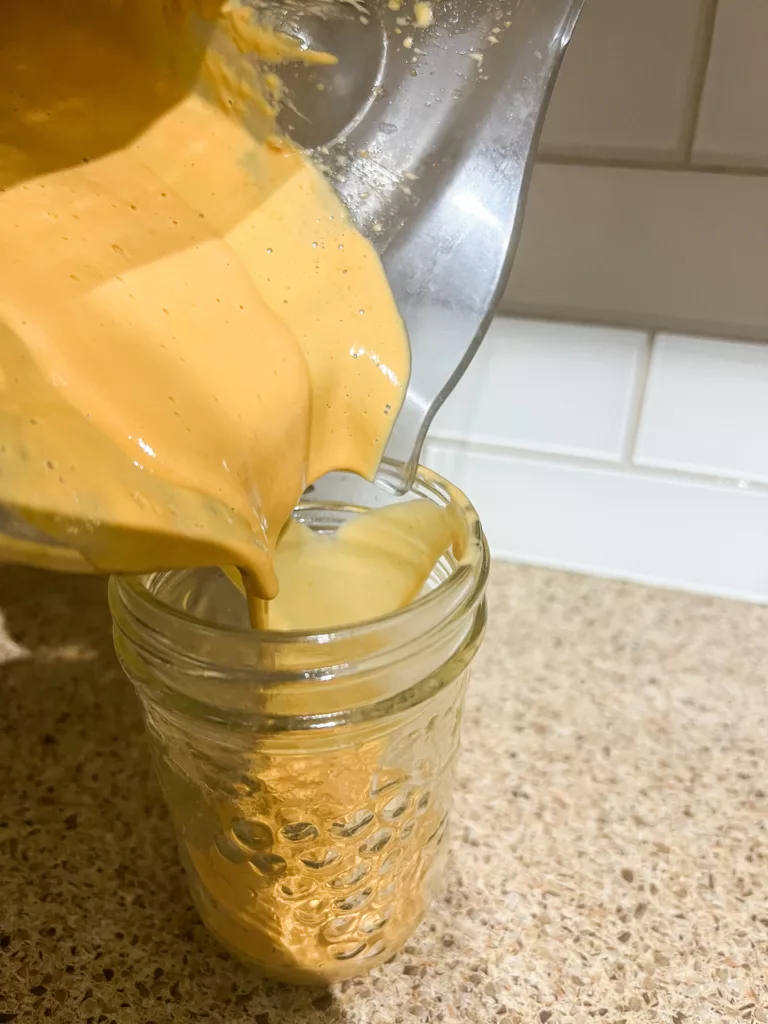 Asian Peanut Sauce pouring into mason jar