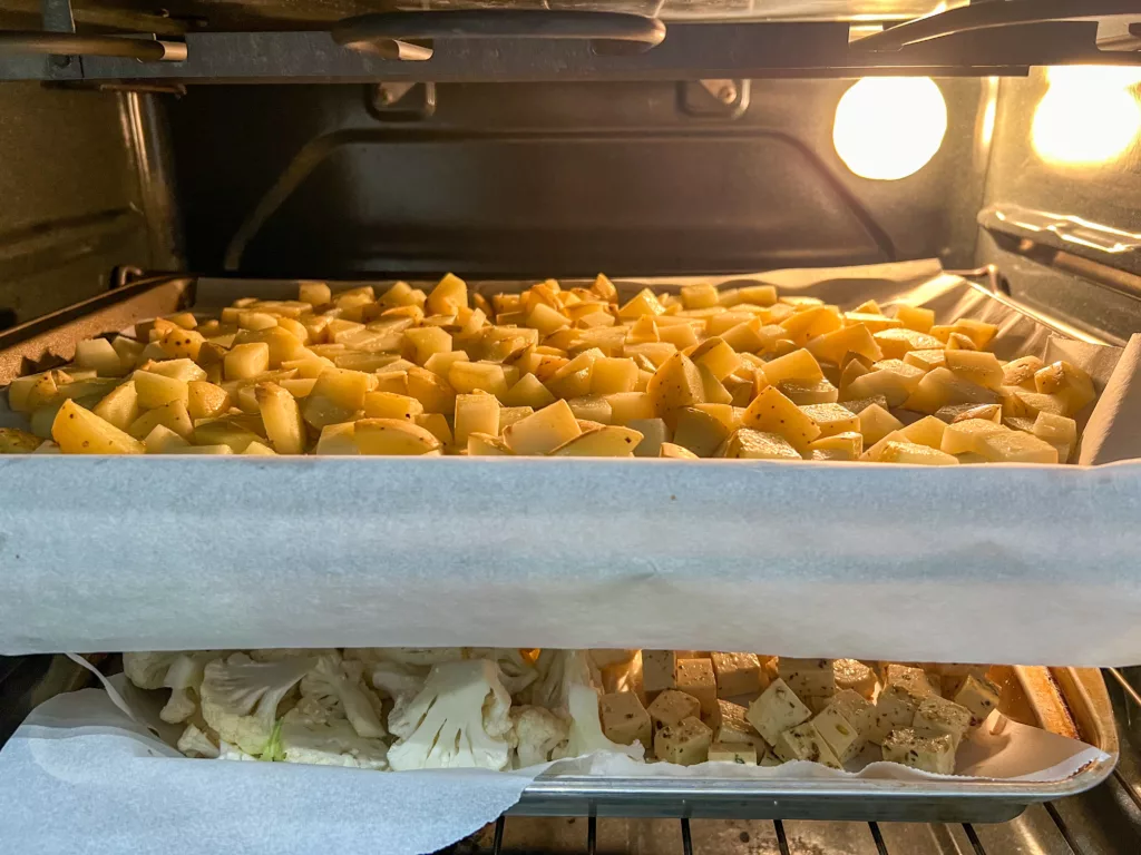 Tofu Sheet Pan With Cauliflower and Potatoes in oven cooking