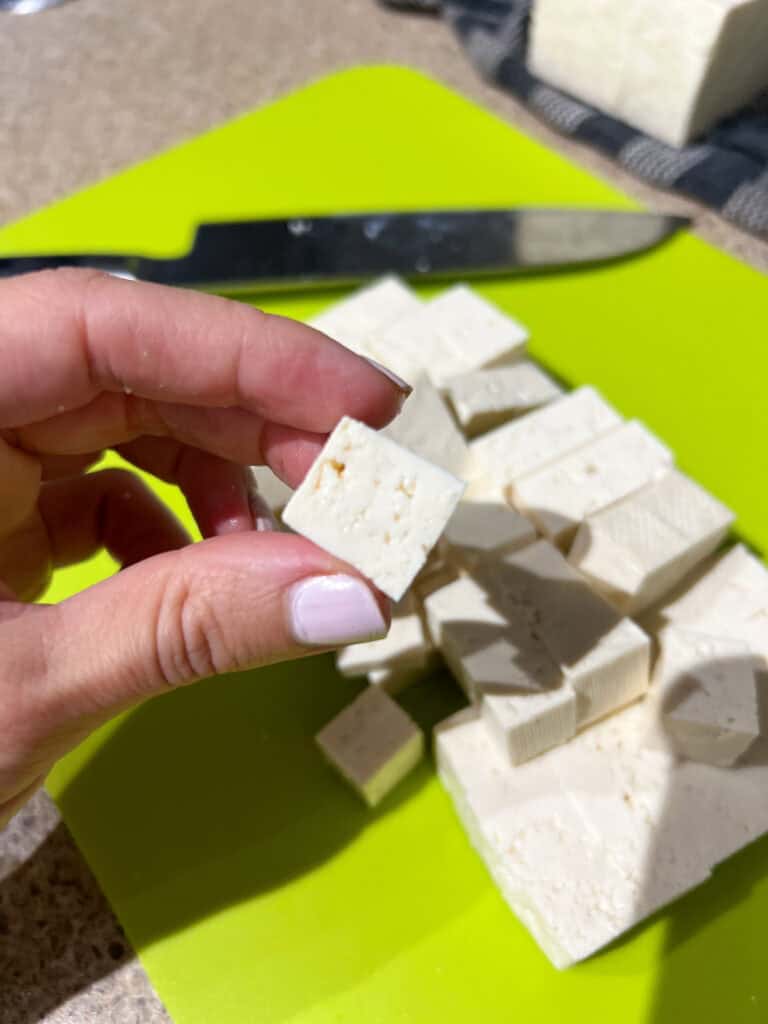 tofu cut into cubes on green cutting board