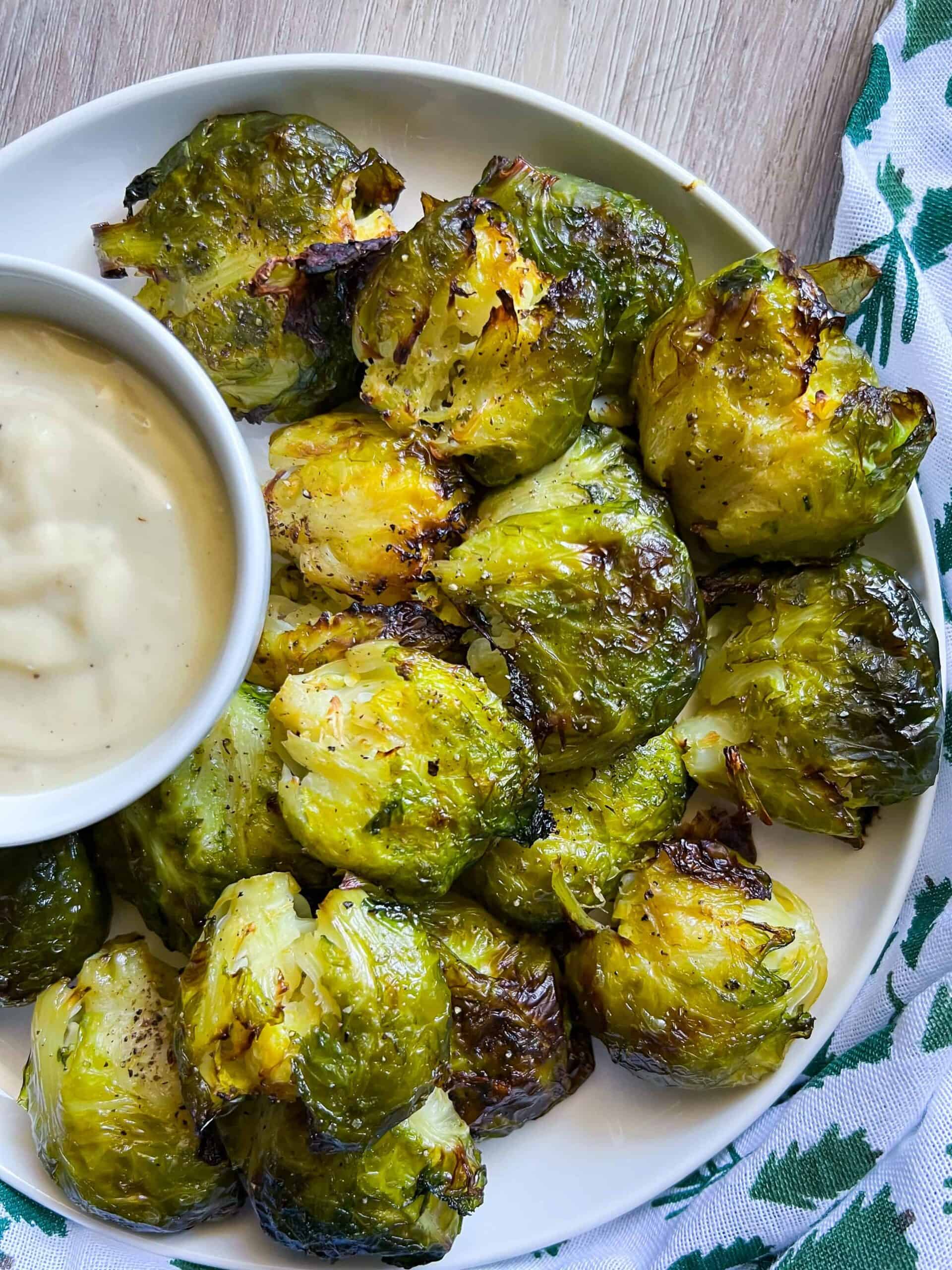 smashed brussels on a plate with dip