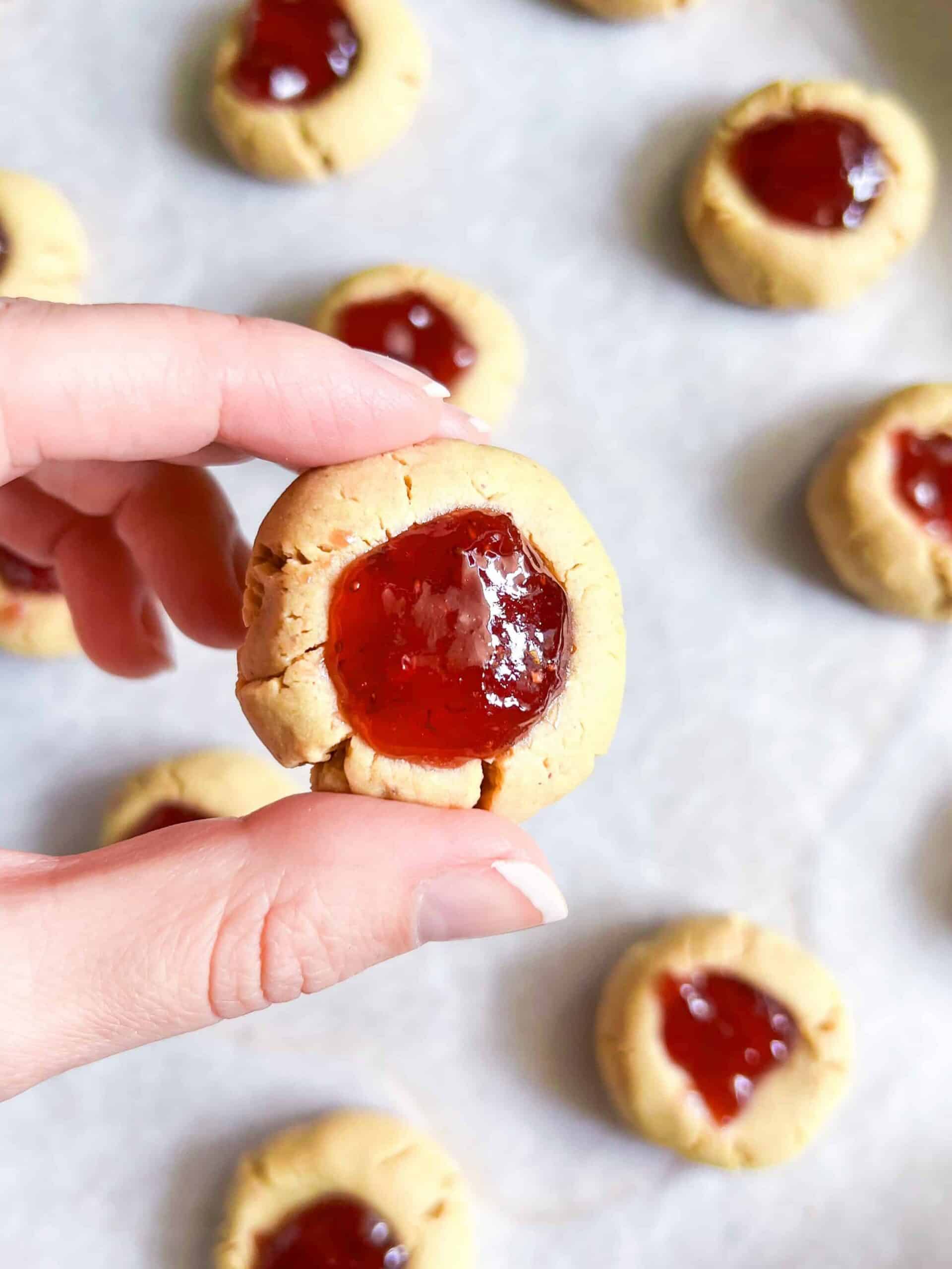 4 ingredient cookies thumb print cookies with jam hand holding cookie