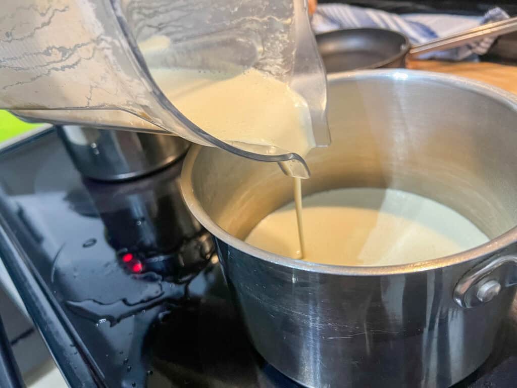 pouring the vegan fondue mixture from blender to pot