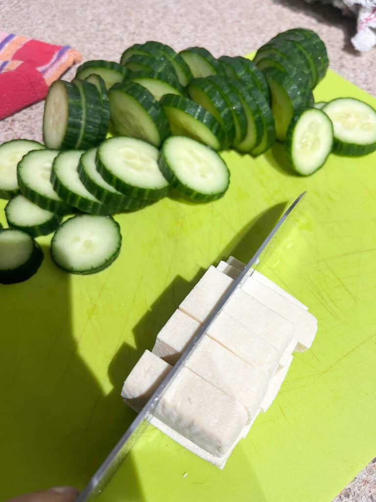 cucumbers and tofu on cutting board