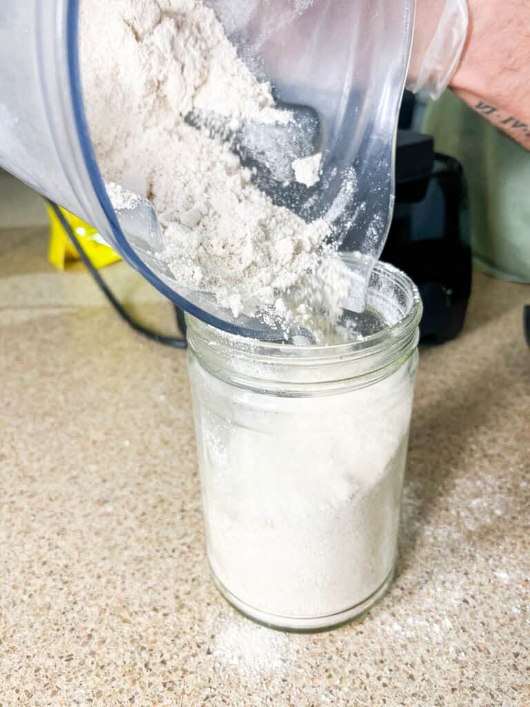 pouring oat flour into glass jar