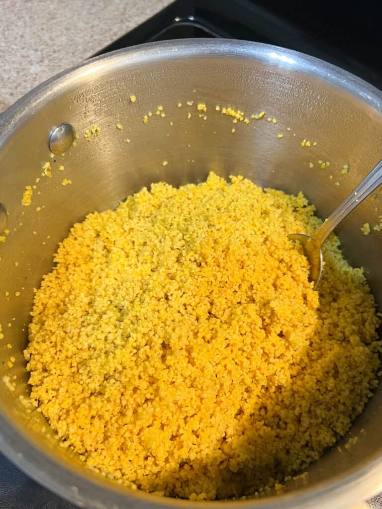 A bowl of yellow rice with a spoon in it