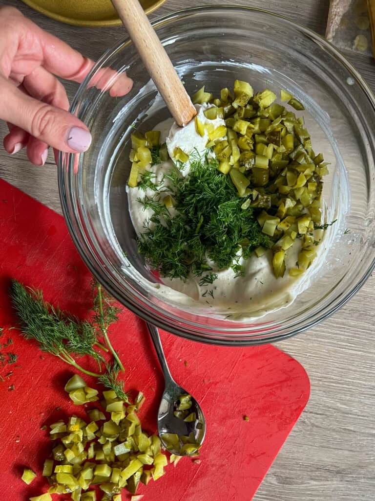 dill pickles cut up in a mixing bowl with fresh dill