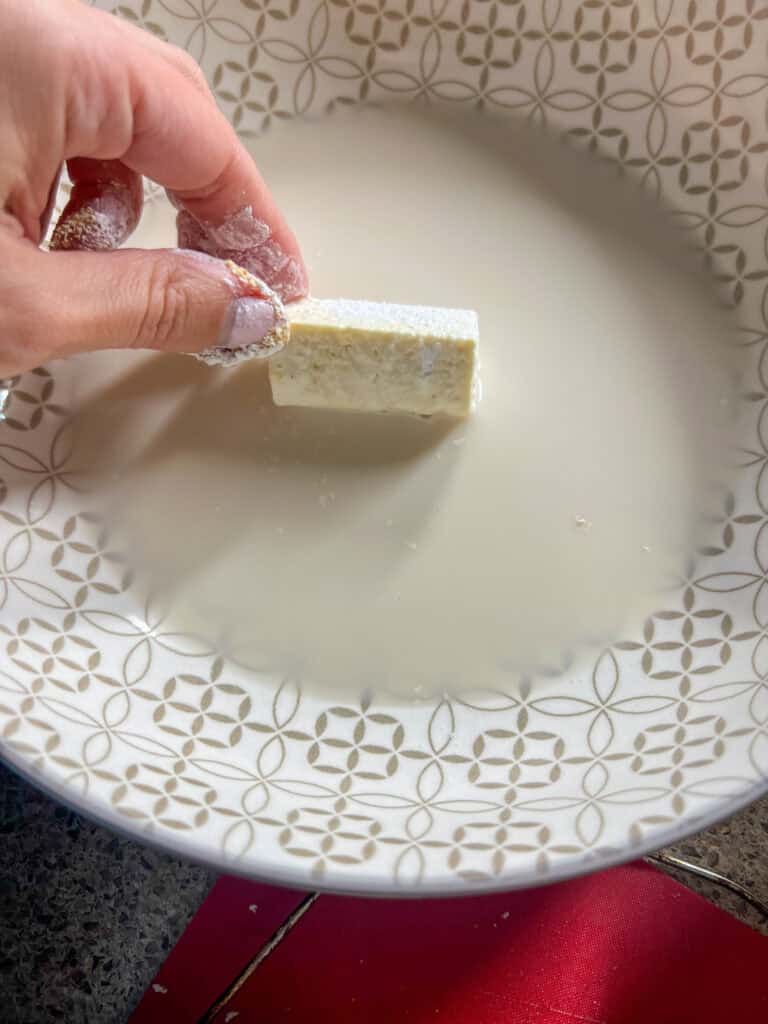 dipping the tofu into mixture to bread