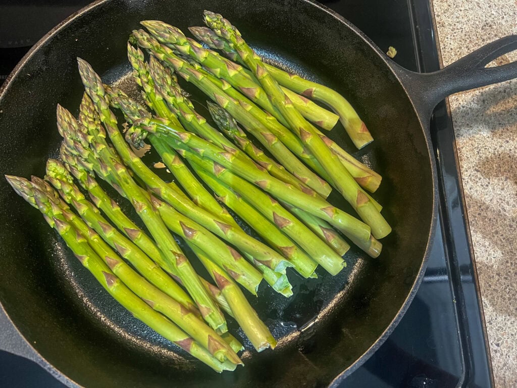 uncooked Asparagus on cast iron pan
