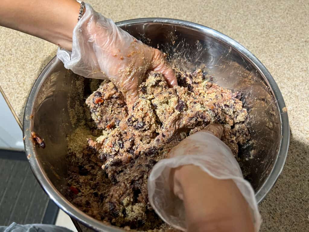 mixing up the Quinoa Black Bean Burgers mixture with 2 hands