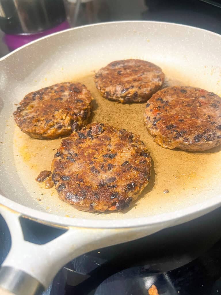 Quinoa Black Bean Burgers cooking on frying pan