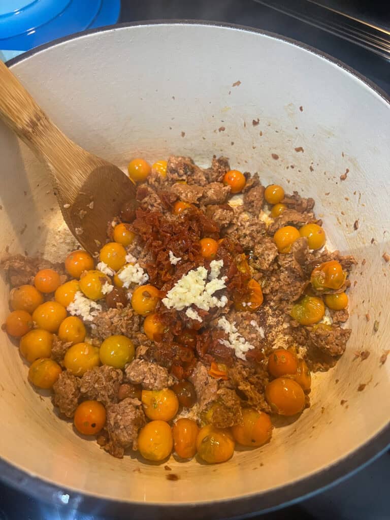adding the garlic to the Cherry Tomato & Sun-Dried Tomato Gnocchi (with Vegetarian Sausage)