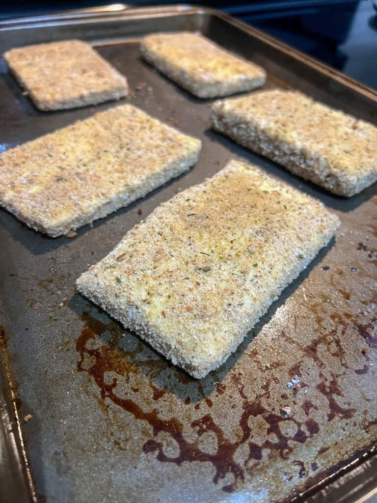 tofu steaks breaded on baking sheet