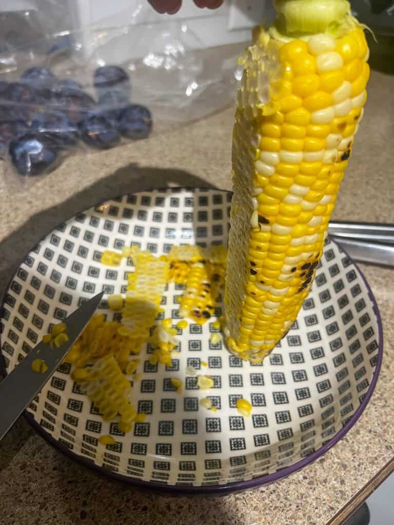 cutting grilled corn off cob