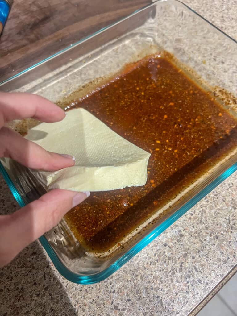 placing tofu in marinade