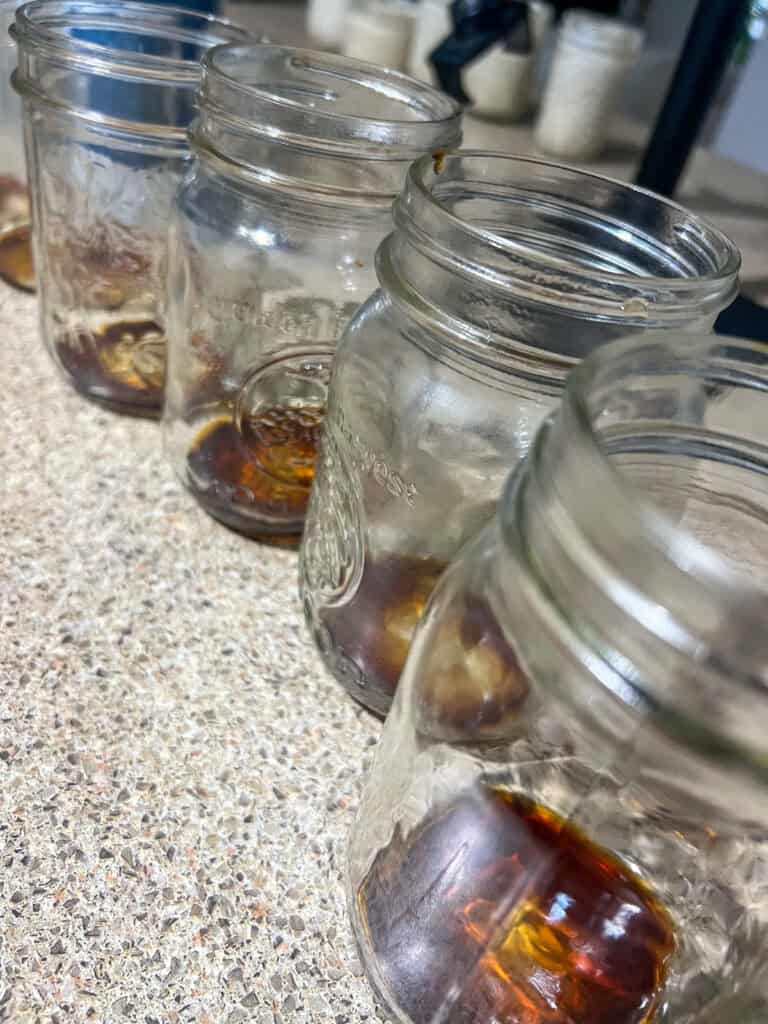 mason jars in a line with sauce in the bottom