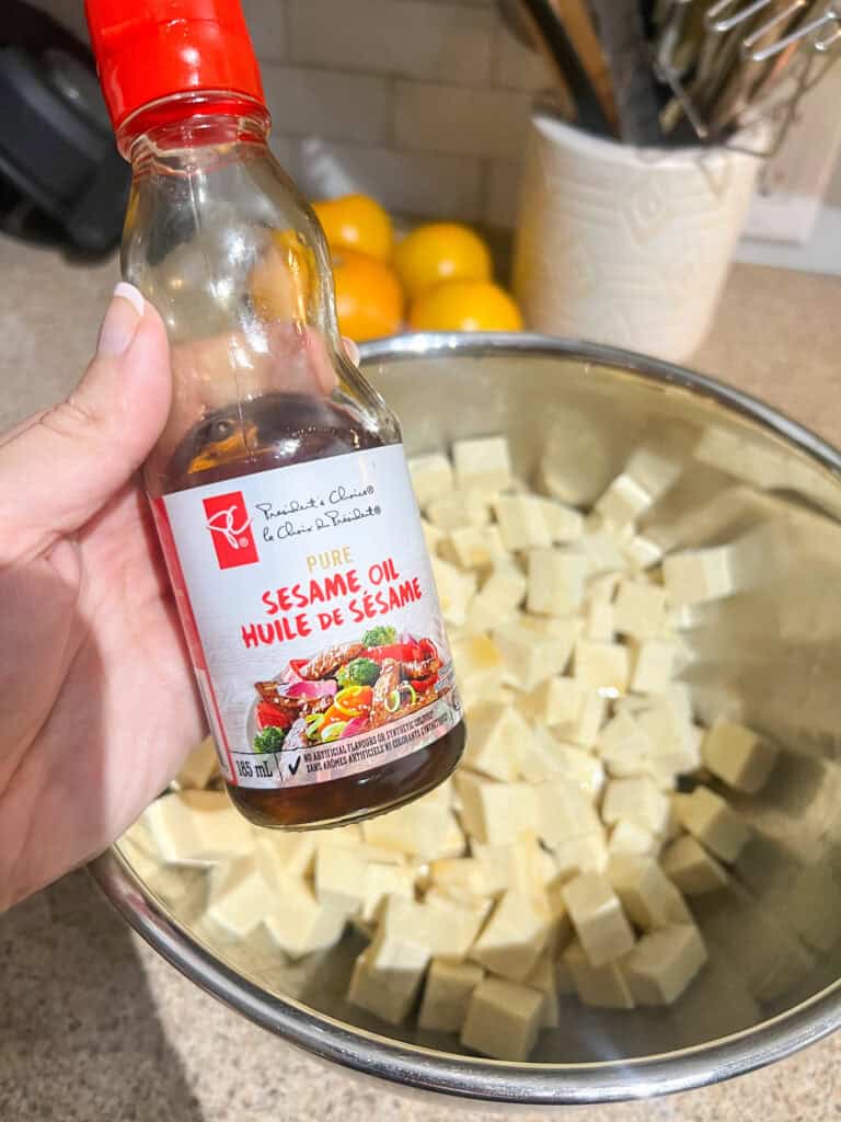 sesame oil with tofu cubed in in the background