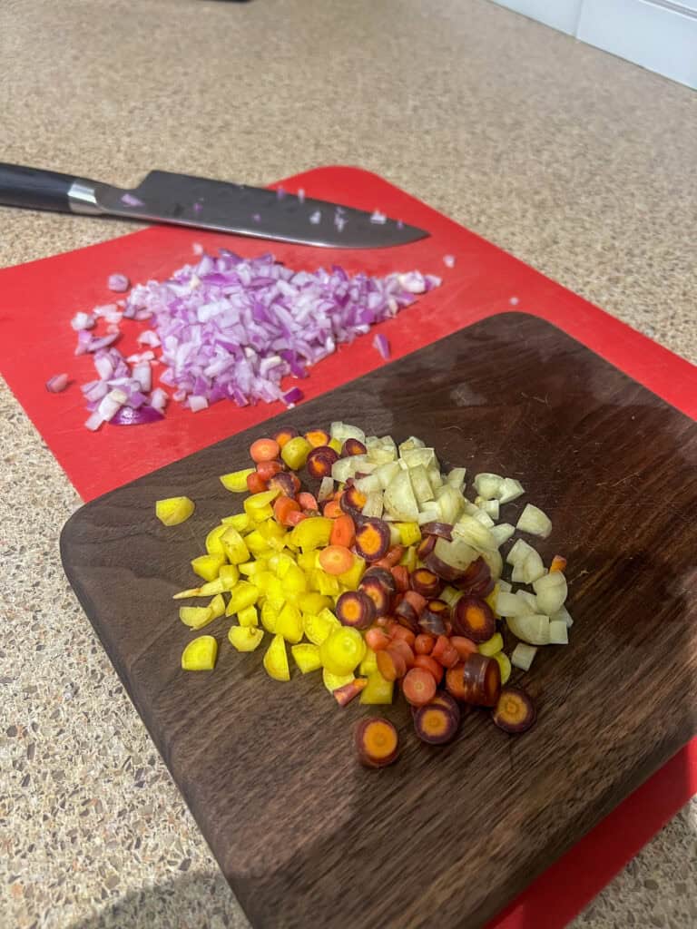 cut up carrots and onion on cutting board