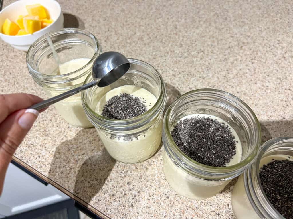 chia seeds added to mango chia pudding