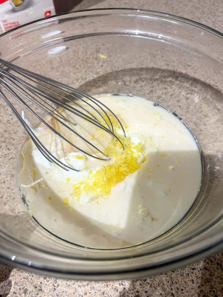lemon loaf ingredients in clear mixing bowl with whisk