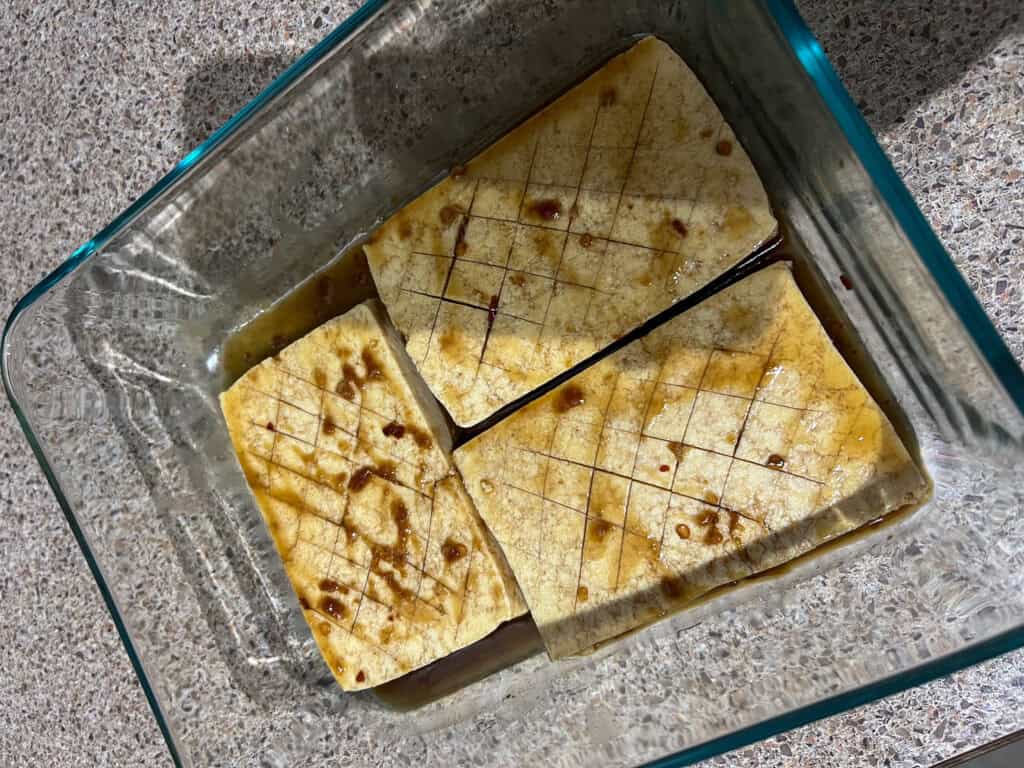 tofu marinating in glass baking dish