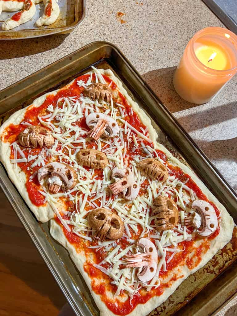 uncooked halloween pizza with mushroom skulls