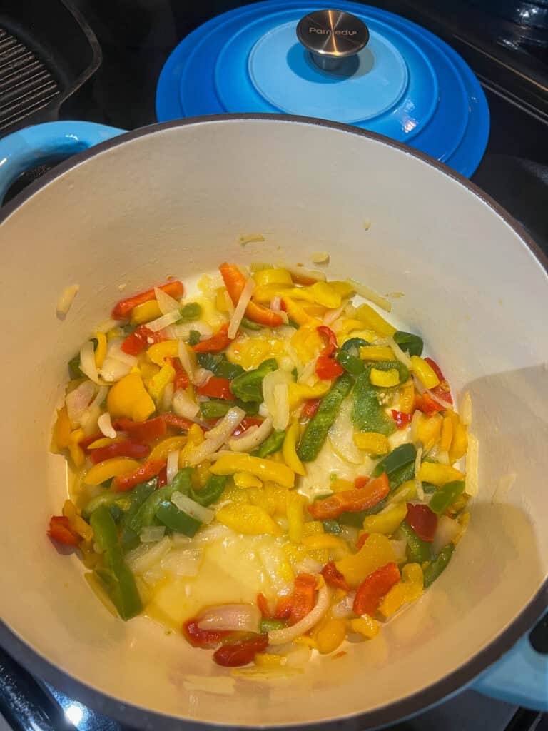 frying onions and peppers in dutch oven