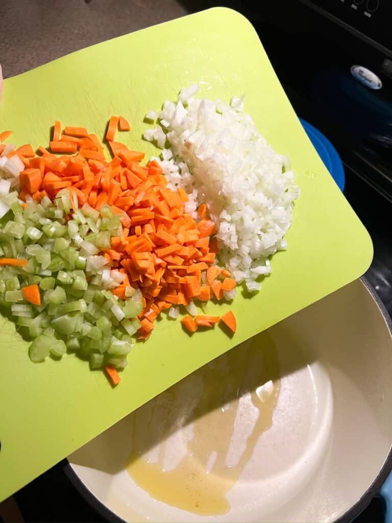 carrots celery and onions on green cutting board
