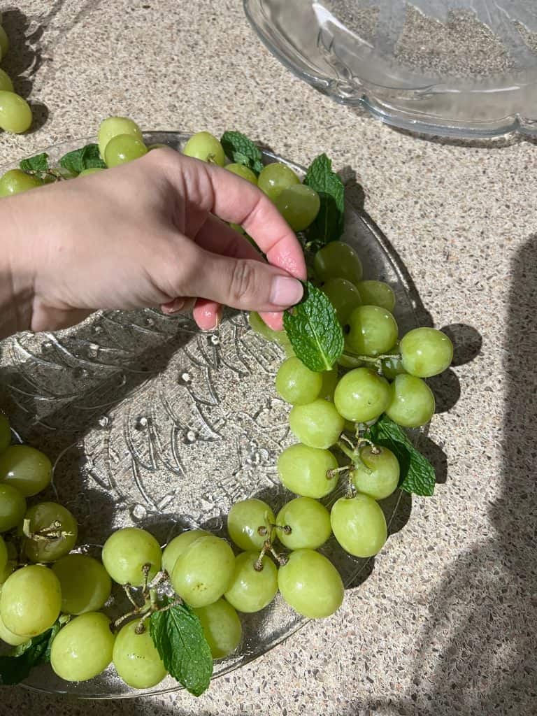 adding mint to fruit wreath