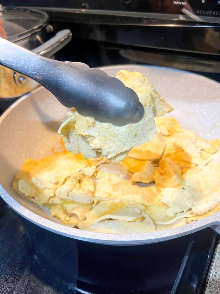 tofu deli slices in the pan held with tongs