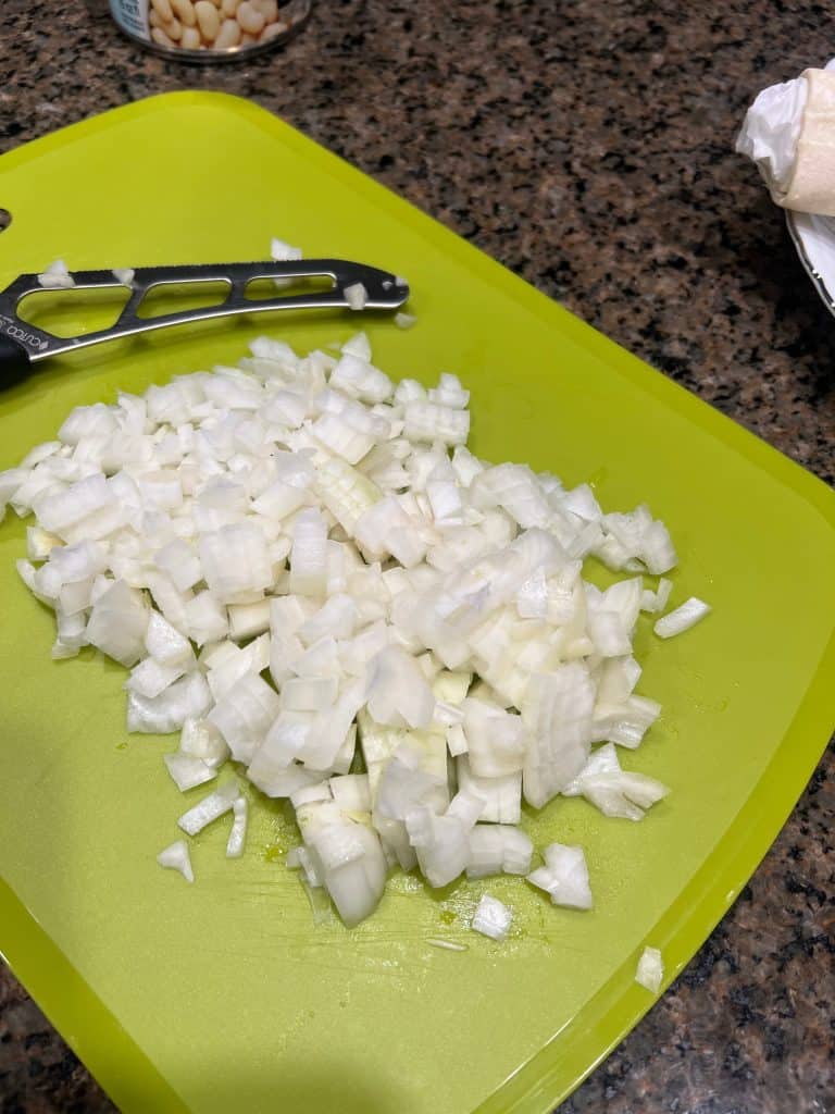 chopped onion with knife and cutting board