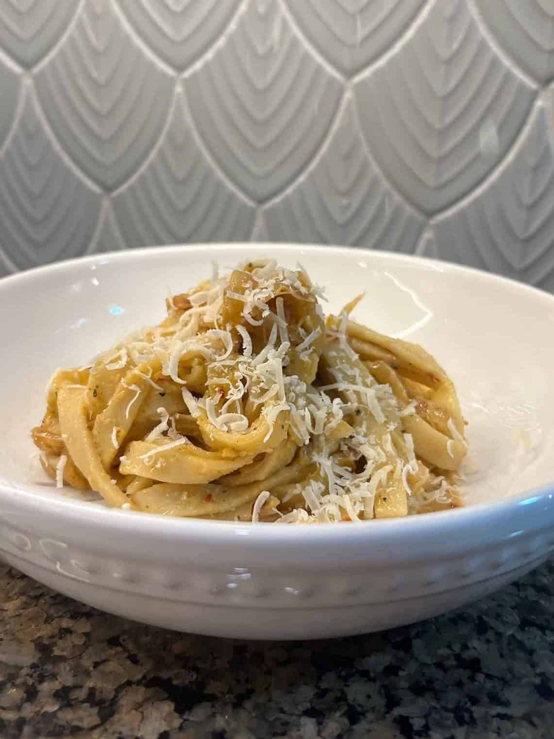 caramelized onion pasta in bowl vegan with parm